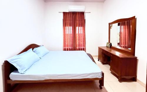 a bedroom with a bed and a mirror and a dresser at Garden Cottage Homestay BB in Wattala