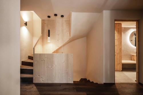 a staircase in a house with a concrete wall at Florisa Mountain Chalet in Tires