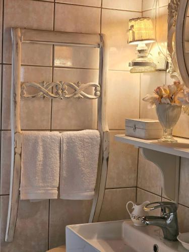 a bathroom with towels and a sink and a mirror at Sophy's Cottage in Politika