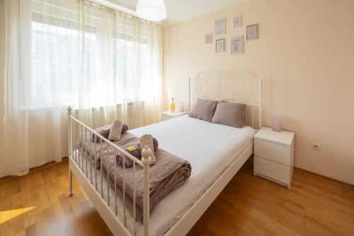 a bedroom with a white bed and a window at Apartment Orchid 021 in Novi Sad