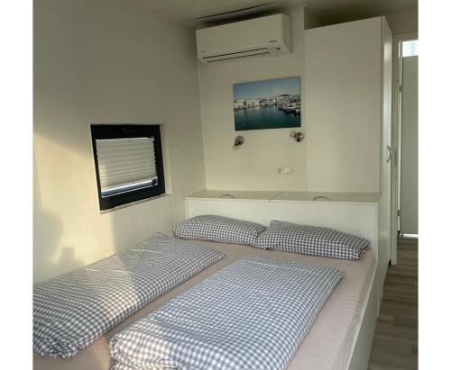 two twin beds in a room with a window at Floating 44 in Xanten - Boot 2 in Xanten