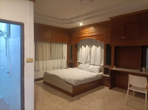 a bedroom with a bed with wooden cabinets and a desk at hatyai homestay greenway orkar in Hat Yai