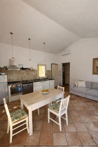a kitchen and living room with a wooden table and chairs at La casa di Fedra in Imperia