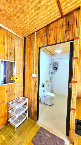 a bathroom with a toilet in a wooden wall at Mon Ngo misty haven B2 in Ban Mae Ta Man