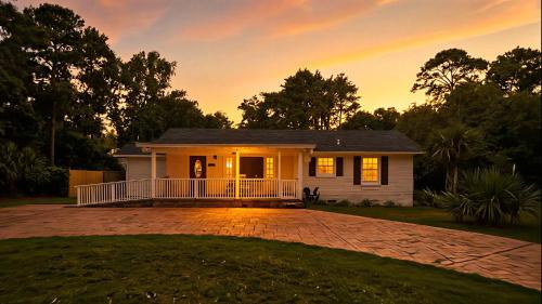 a small white house with a porch at sunset at Charming 3-bedroom house in Wilmington with WiFi, AC in Wilmington