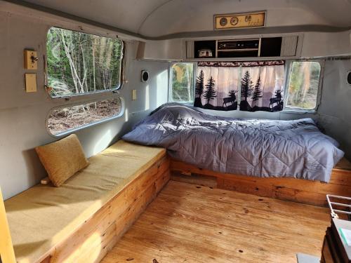 a bed in the back of a campervan with two windows at Orange Lake Airstream in Whiting