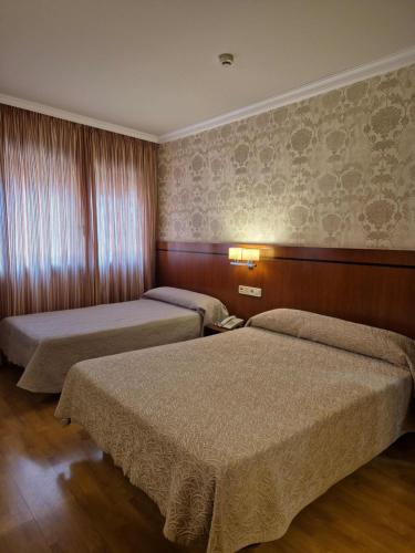 a hotel room with two beds in a room at Hotel HHB Pontevedra Confort in Pontevedra