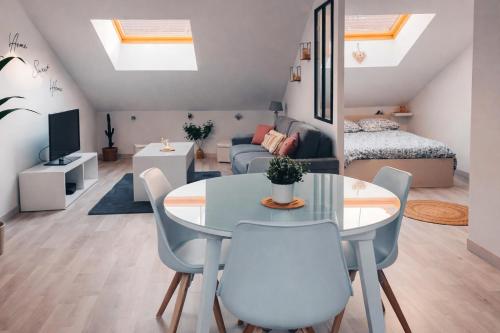 a room with a table and chairs and a bedroom at Charmant Loft climatisé 50 m de la gare in Chalon-sur-Saône