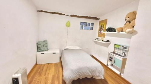 a small bedroom with a bed and a teddy bear on the wall at Casa Rural NEREA in Letux