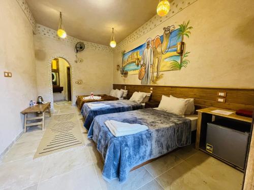 a hotel room with two beds and a tv at SiwaTu Lodge in Siwa