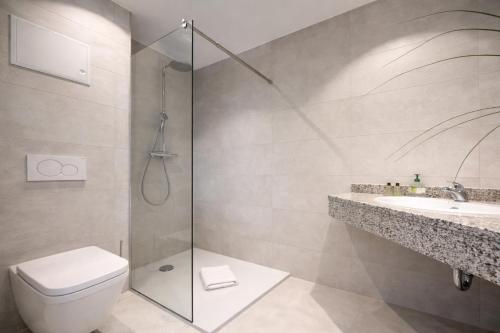 a bathroom with a shower and a toilet and a sink at Oceanview Residences Lauterbach Rügen Ostsee erste Reihe in Putbus