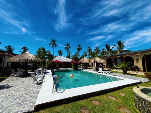 a swimming pool with chairs and umbrellas at Show Pony Ranchero Resort - Boutique Beach Hotel in Las Lajas