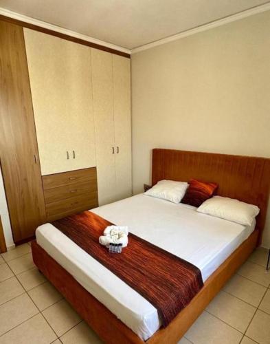 a bedroom with a large bed with a wooden headboard at K A P Home in Chios