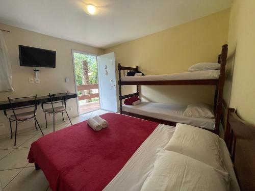 a bedroom with two bunk beds and a desk at Flat Salto Dagua Penedo in Penedo