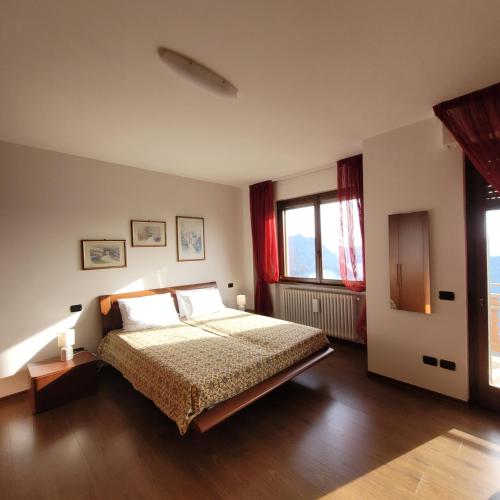 a bedroom with a bed and two windows at A Rimirar il Lago Mountain Lake Iseo Hospitality in Bossico