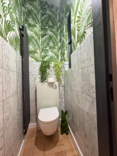 ein Badezimmer mit Toilette und Pflanzen an der Wand in der Unterkunft Dream flat in Pilsen