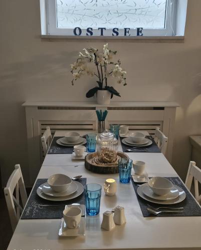 ein Esstisch mit blauen Gläsern und Tellern in der Unterkunft Ferienwohnung Lakeside in Heiligenhafen
