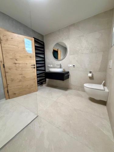 a bathroom with a sink and a toilet and a mirror at Ferienhaus Wolfi in Eberndorf