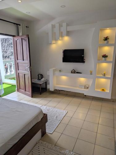 a bedroom with a flat screen tv on a wall at Belle Atelier in Ukunda