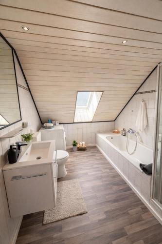 a bathroom with a sink and a tub and a toilet at Kuzey Apartments in Kappel-Grafenhausen
