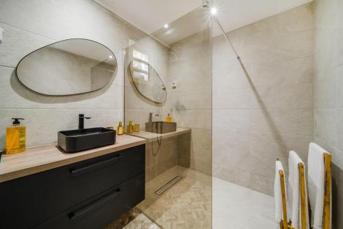 a bathroom with a sink and a mirror at Villa Cocon Jacuzzi in Saint-Pierre