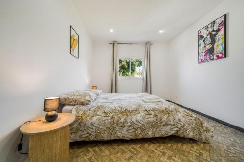a bedroom with two beds and a table and a window at Villa Cocon Jacuzzi in Saint-Pierre
