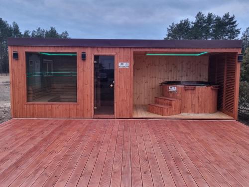 a wooden building with a hot tub in it at Agroturystyka zielone wzgórze in Swornegacie