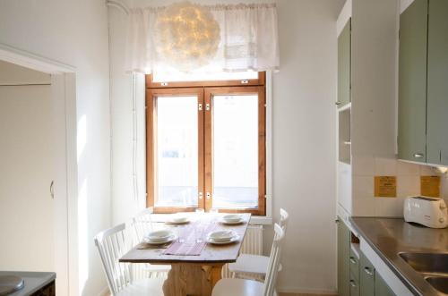 a kitchen with a table with chairs and a window at Studio Skata in Pietarsaari