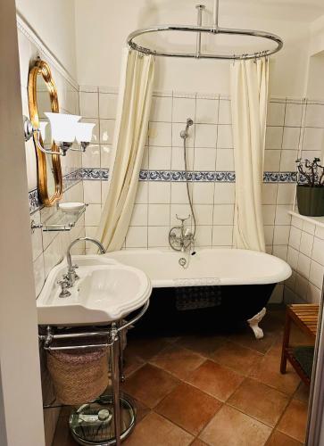 a bathroom with a tub and a sink at Villa Conte Private Urban Hideaway in Wels