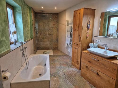 a large bathroom with a tub and a sink at Gästehaus Watzmannblick in Bischofswiesen