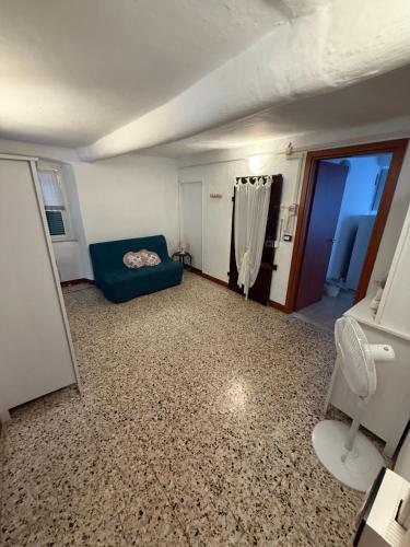 a room with a blue couch and a bathroom at Alba in Mele