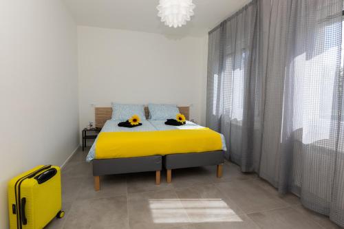 a bedroom with a yellow bed and a yellow suitcase at Gradisca Go Home in Gradisca dʼIsonzo