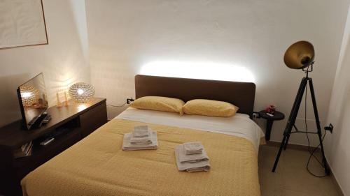 a bedroom with a bed with two towels on it at Alle volte… in Bisceglie