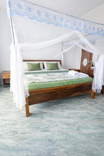 a bedroom with a bed with a canopy at Rusal Haven in Rubavu