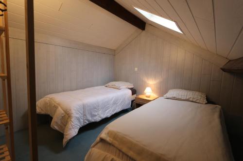 a bedroom with two beds and a light on the ceiling at Appart Hotel cholet centre in Cholet