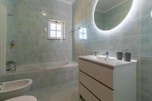 a bathroom with a sink and a tub and a toilet at Casa Laranjal in Albufeira