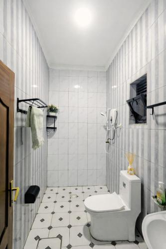 a white bathroom with a toilet and a sink at Rusal Haven in Rubavu