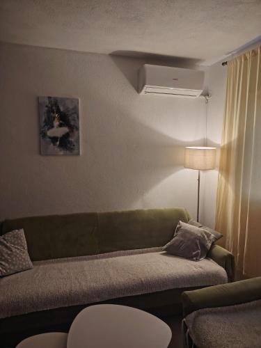 a living room with a green couch and a lamp at Apartman Vera in Bileća