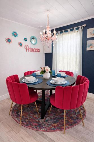 a dining room with a black table and red chairs at NEW Beach Cozy Bungalow 2B Mins-beach&downtown in Clearwater
