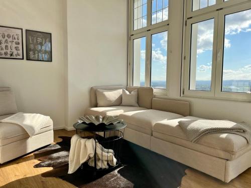 a living room with a couch and some windows at Wohlfühl-Apartment Elbtal in Radebeul