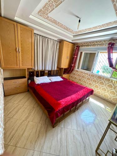 a bedroom with a large bed with a red blanket at Nador cornich calme in Nador