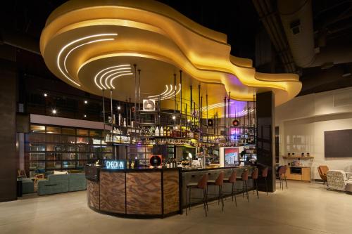 a restaurant with a bar with a yellow ceiling at Moxy Atlanta Downtown in Atlanta
