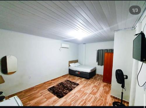 a bedroom with a bed in the middle of a room at Recanto Remanso in Queimados