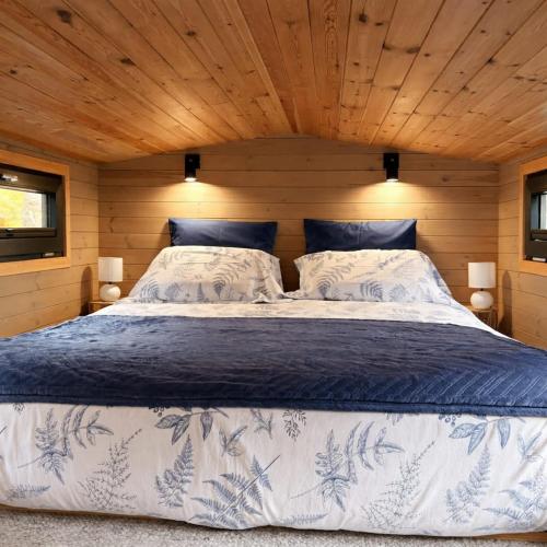 a bedroom with a large bed in a wooden room at La Tiny House de Nanou in Rochefort