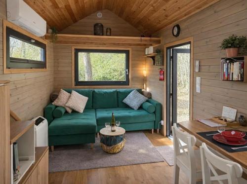 a living room with a green couch and a table at La Tiny House de Nanou in Rochefort