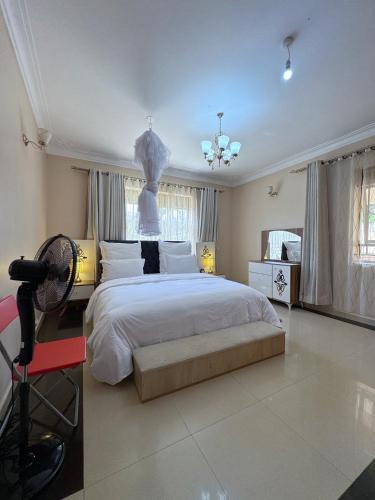a bedroom with a large white bed with a ceiling at The Terrace Villa in Kampala