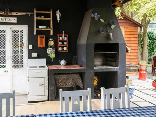 a kitchen with a pizza oven with a table and chairs at Oude Pastorie in Cradock