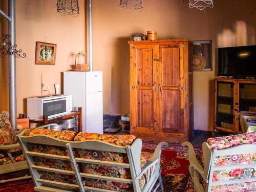 a living room with a couch and a wooden cabinet at Oude Pastorie in Cradock