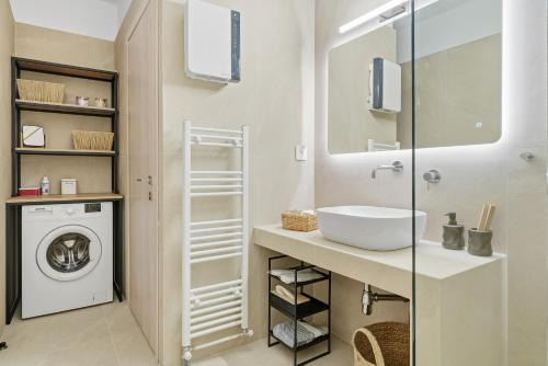 a bathroom with a sink and a washing machine at Calma Ioannina Apartment in Ioannina
