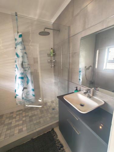 a bathroom with a sink and a shower at Aloe Shore- Whale Watch from Balcony- Stunning in Umdloti